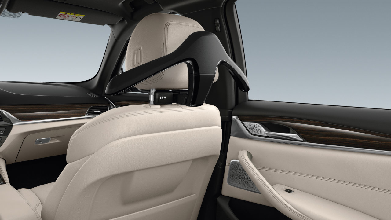 A coat hanger from the BMW Travel and Comfort System is attached to the back headrest of a BMW passenger seat.